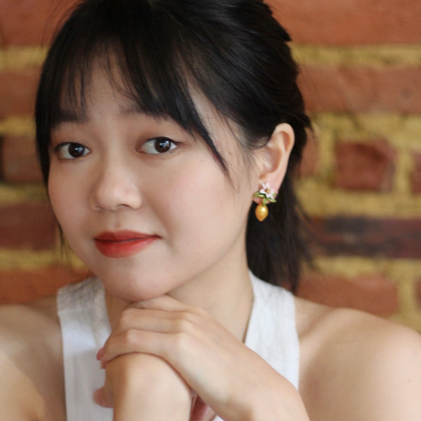 A cute woman wears the citrus blossom earrings